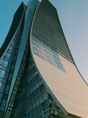 Photo by Malek Ghali A contemporary curved skyscraper reaching towards the sky, showcasing modern architectural design.