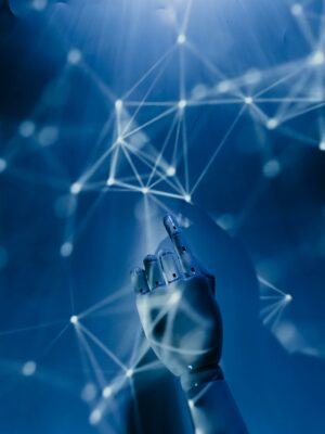 Photo by Tara Winstead A robotic hand reaching into a digital network on a blue background, symbolizing AI technology.