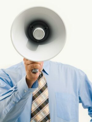 Photo by Pressmaster Businessman in blue shirt holding megaphone, symbolizing leadership and communication.