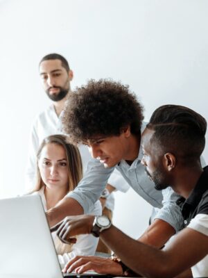 Photo by Thirdman Group of professionals engaging in a collaborative discussion around a laptop in a modern office setting.